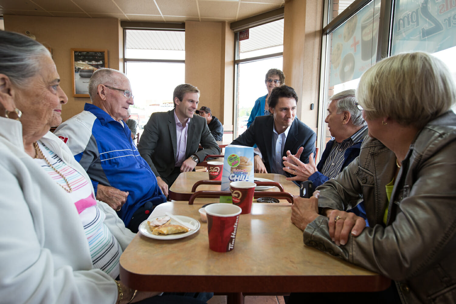 Justin, Brian Gallant et le député libéral Dominic LeBlanc rencontrent les résidents de Quispamis dans un Tim Hortons. 13 juin 2014.